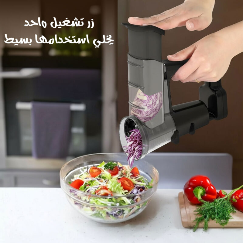 يد تستخدم القطاعة الكهربائية لتقطيع الخضار، مع وعاء سلطة أسفل الجهاز